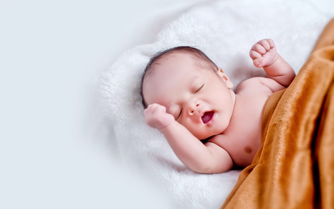 baby lying on white fur with brown blanket