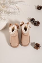 Pair of kids beige snuggle boots showing soft cream lining and ribbon bows Pair of kids beige snuggle boots showing soft cream lining and ribbon bows